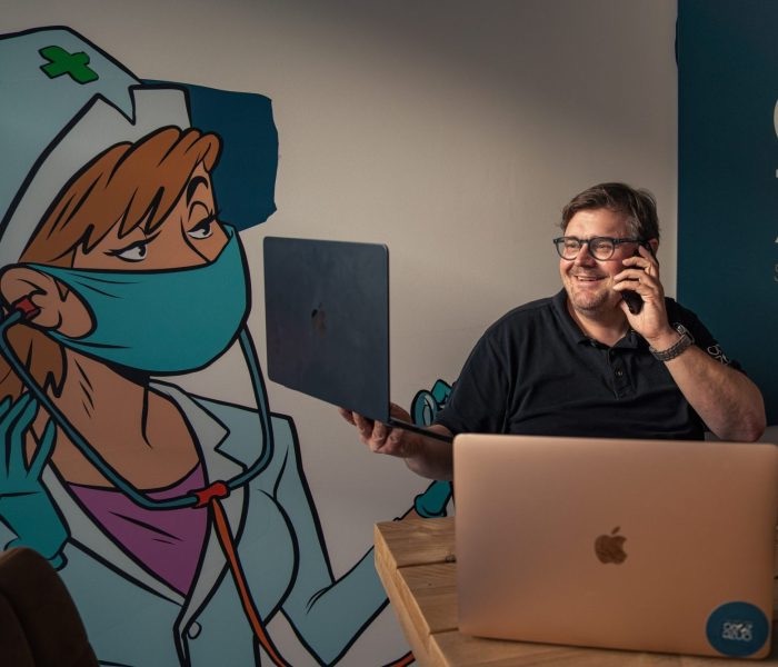 Oprichter van CareSpot aan de telefoon achter zijn laptop