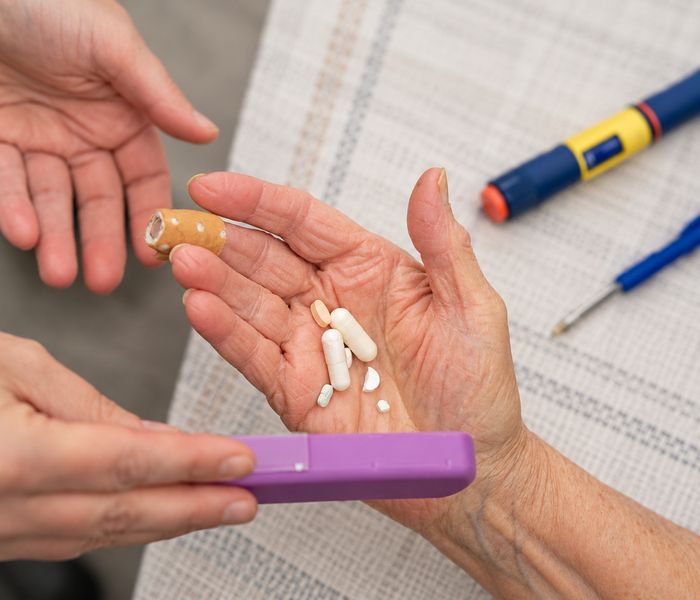 Medicatie wordt uit een pillendoos genomen