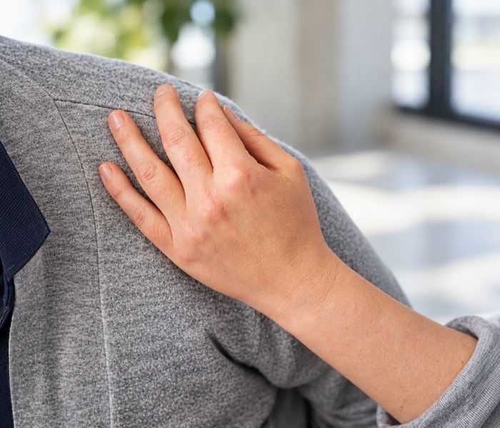 Zorgzame hand op de schouder van een patiënt