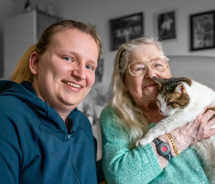 Thuisverpleegkundige bij een oudere patiënte en haar kat